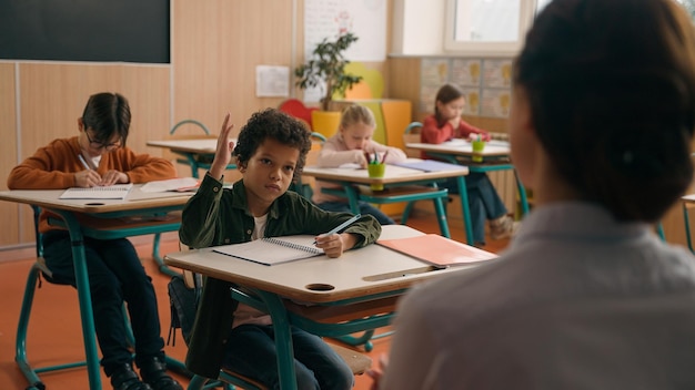 unrecognizable woman teacher tutor ask children lesson check knowledge of pupils schoolboy little