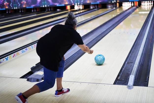 Unrecognizable woman throwing a ball in a bowling alley