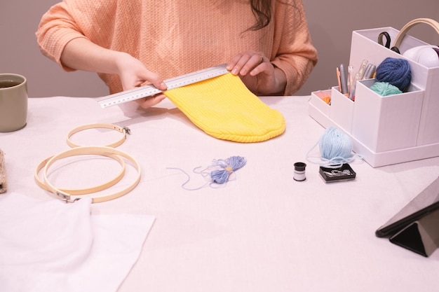 Unrecognizable woman using a ruler to measure a wool hat