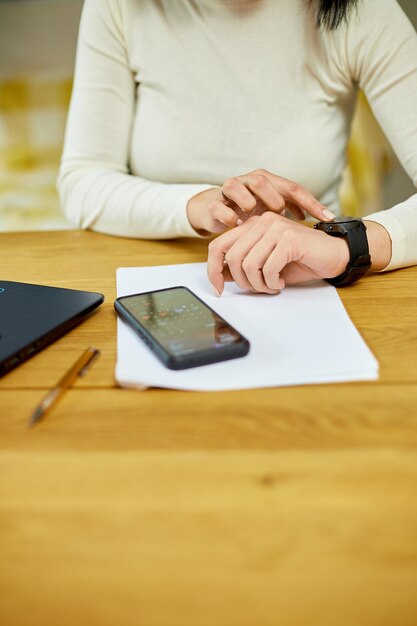 Unrecognizable woman using smartwatch Freelancer female with smart watch