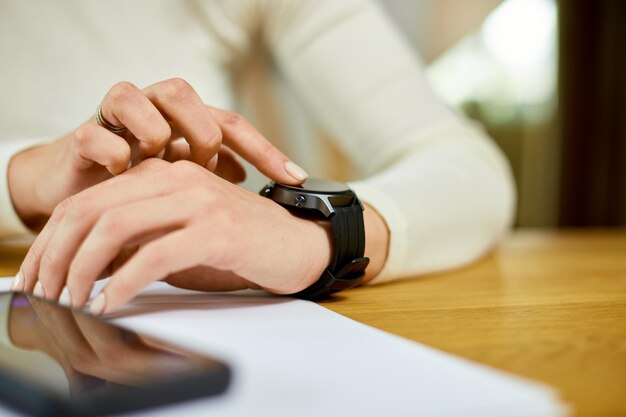 Unrecognizable woman using smartwatch Freelancer female with smart watch