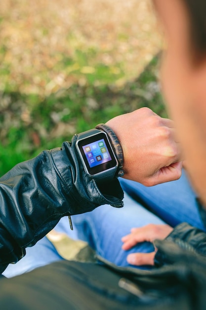 Photo unrecognizable young man looking at his smartwatch