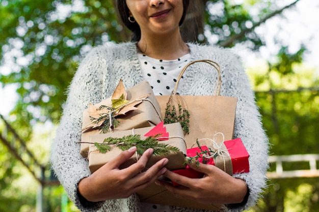 Foto giovane donna irriconoscibile che tiene i regali di natale