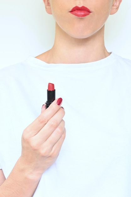 Photo unrecognizable young woman holding red lipstick