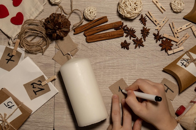 unrecognizable young woman paint numbers on candles female making homemade advent calendar made