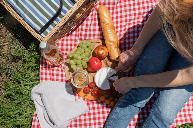 Unrecognizable young woman in park outside at sunny day enjoying summertime dreaming and drinking wine