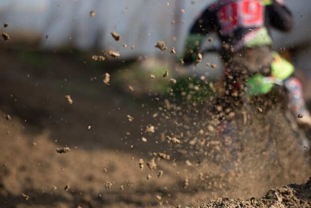 Фото Непризнанный спортсмен едет на спортивном мотоцикле и грязном колесе на гонке мотокросса