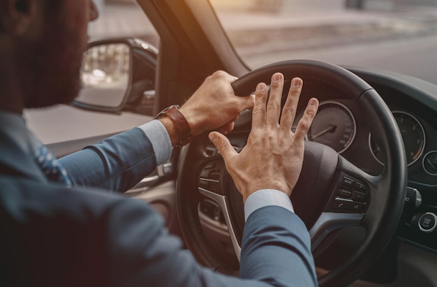 Unrecognized male pushing on the wheel of the automobile