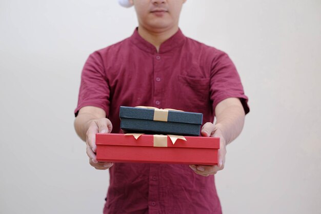 사진 알 수 없는 남자 의 손 은  바탕 에 금 리본 으로 감싸진 작은 선물 상자 를 들고 있다