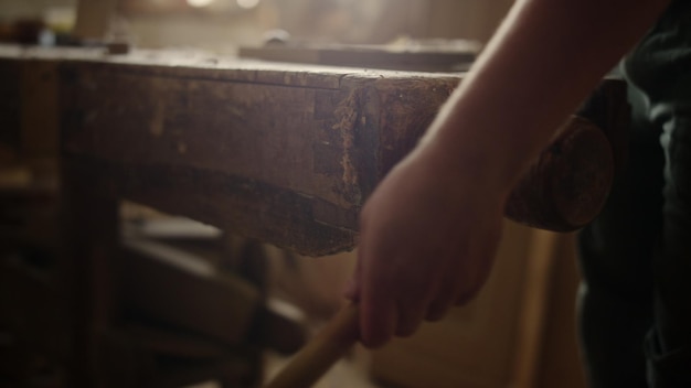 Unrecognized man working on wood lathe machine in carpentry workshop Unknown wood worker preparing wood in studio Closeup man hands pressing wooden plank indoors