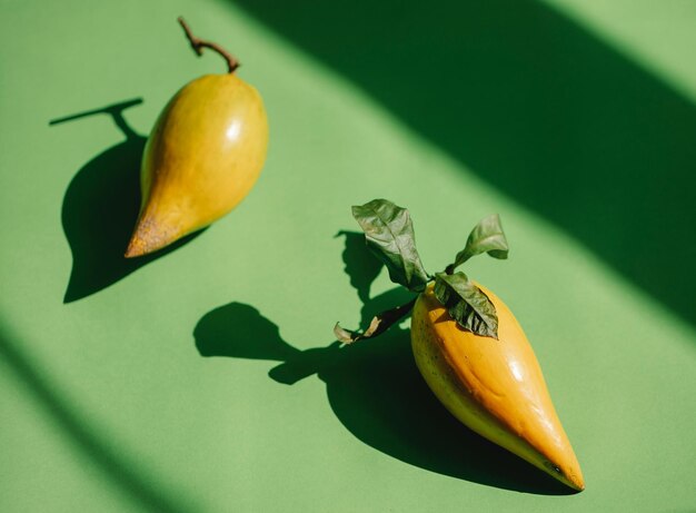 Unripe pears lying on green background