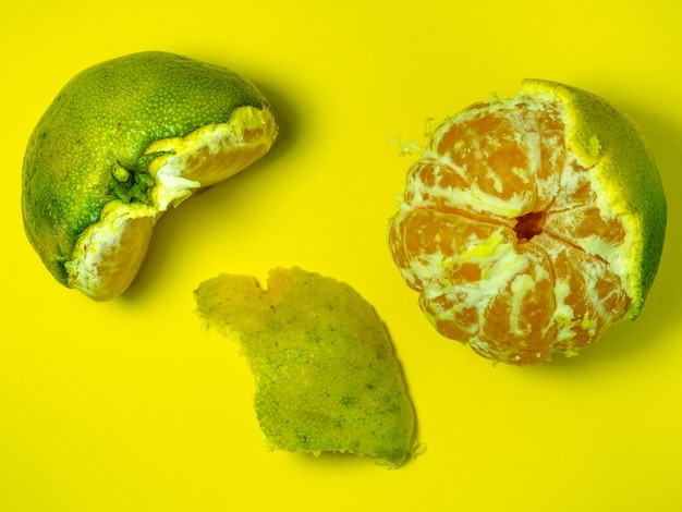 노란색 배경에 미숙한 만다린을 는 녹색과 노란색의 만다린 <unk>은 성분 <unk> 고립 된 만다린 조각 유용한 과일