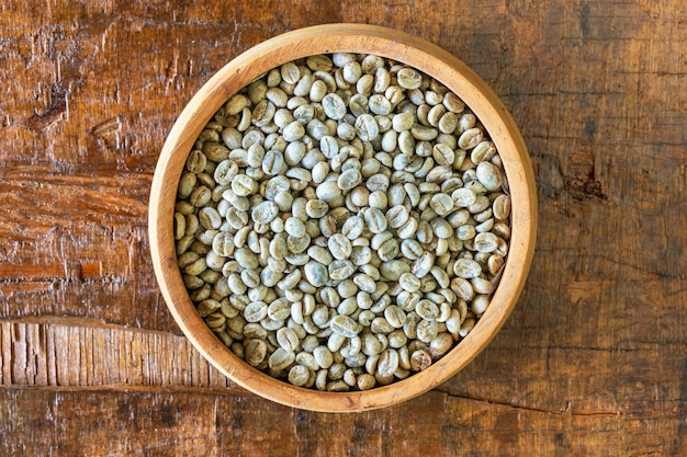 Unroasted green coffee beans in a wooden bowl