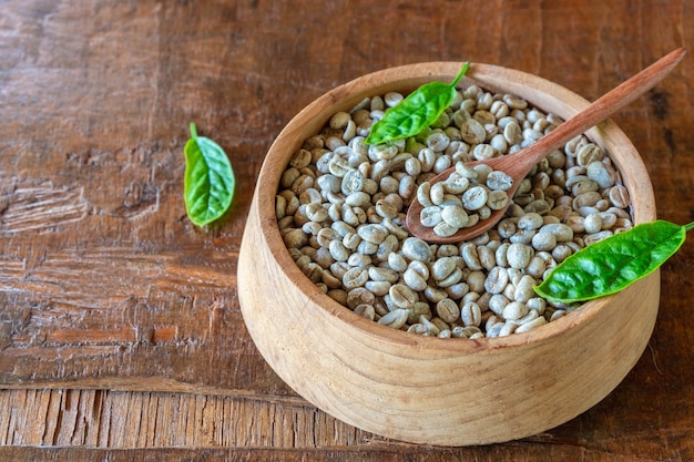 Unroasted green coffee beans in a wooden bowl