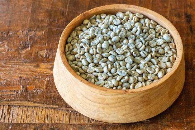 Unroasted green coffee beans in a wooden bowl