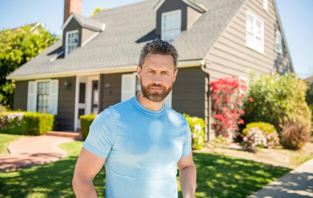 Unshaven guy standing near new house realtor