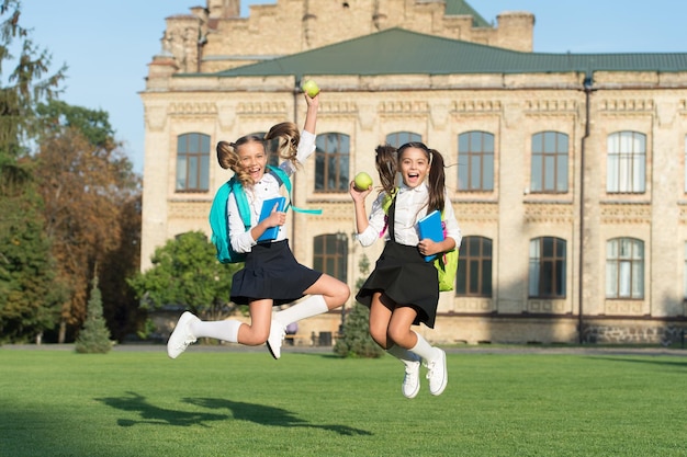 学校のコンセプトに戻る小さなジャンプ女子校生の学校の背景の止められないエネルギー