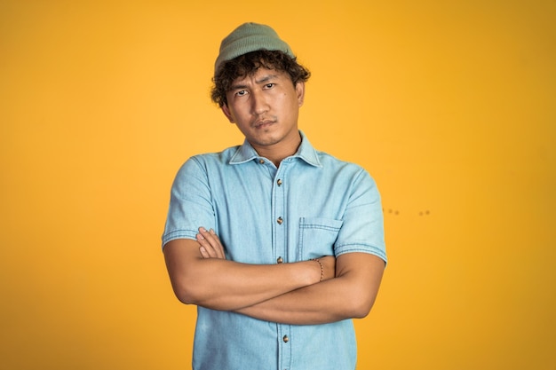 Unsure asian young man thinking on isolated background