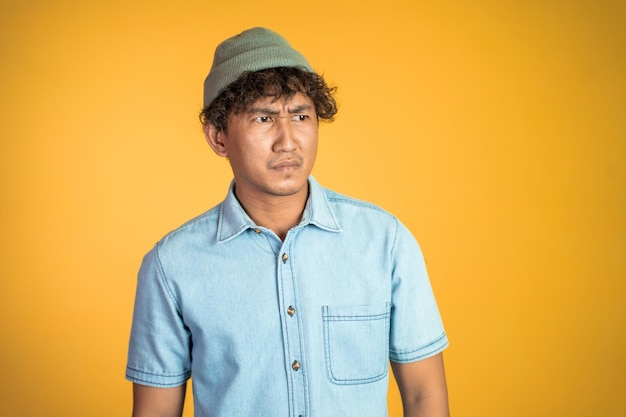 Unsure asian young man thinking on isolated background