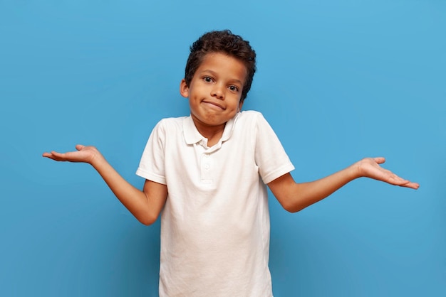 白いTシャツを着た不確実なカラフルなアフリカ系アメリカ人の男の子が肩を振る