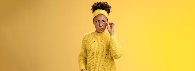 Unsure thoughtful hesitant cute africanamerican millennial teenage girl in round glasses sweater hea