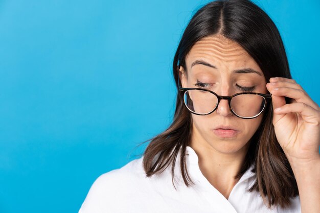 Untrusting hispanic woman looking over glasses at side