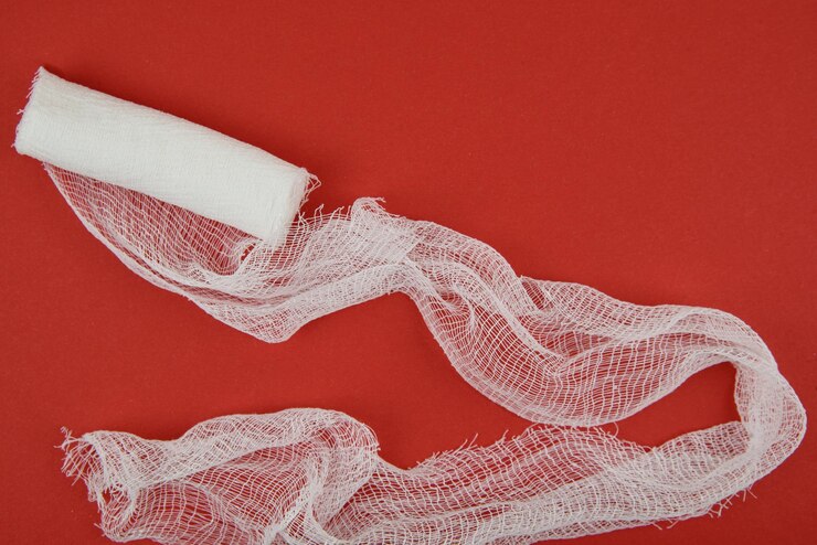 The untwisted bandage lies on a red background