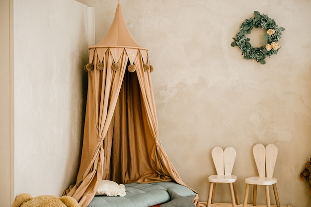 Unusual cot with high yellow curtains.