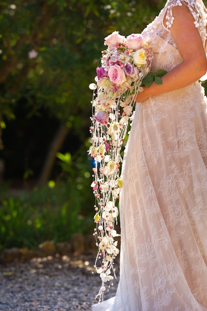 Un insolito bouquet da sposa allungato nelle mani della sposa.