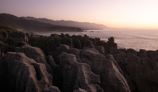 unusual rock formations on oceans coast shot during sunsetpunakaiki pancake rocksnew zealand