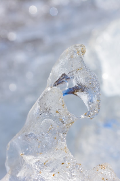 Необычные формы и текстуры кристаллов льда крупным планом неглубокой глубины резкости с копией пространства. Зимний и весенний пейзаж.