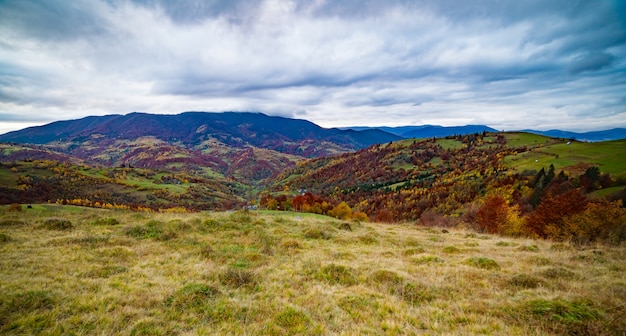 Unusually beautiful nature of the Carpathian mountains in beautiful hills, fantastic sky of colorful forests and a small village