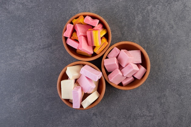 Unwrapped sugar free chewing gum sticks placed on a stone table .