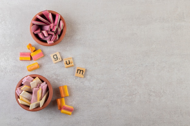 Unwrapped sugar free chewing gum sticks placed on a stone table .