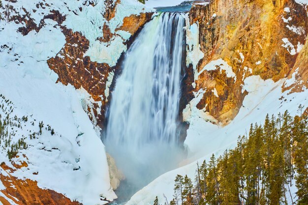 Photo up close to amazing yellowstone upper falls in winter snow