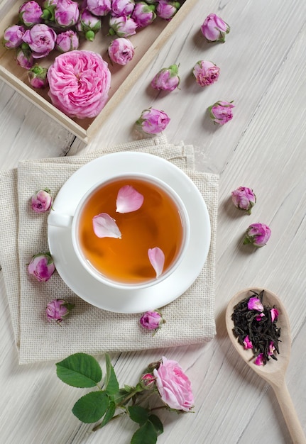 ÃÂÃÂÃÂÃÂÃÂÃÂÃÂÃÂ¡up of tea, rosebuds and wooden spoon with tea on  white wooden table. Top view.