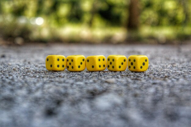 Photo up of yellow dice on road