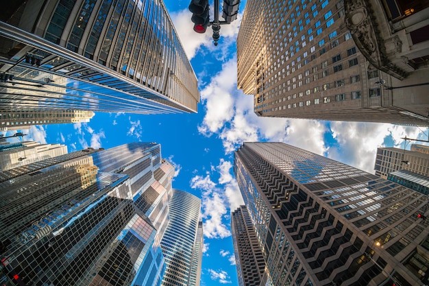 Uprisen-hoek met fisheye-scène van de wolkenkrabber van Downtown Chicago met weerspiegeling van wolken tussen hoge gebouwen met een vliegtuig dat over de hemel vliegt, Illinois, Verenigde Staten, Business en Perspectief