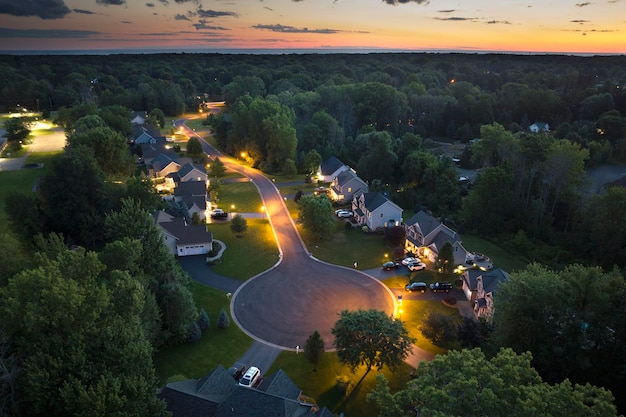 Foto upscale voorstedelijke huizen bij zonsondergang met grote achtertuinen en groene grasvelden verlichte particuliere woonhuizen in het landelijke voorstedelijke uitgestrekte gebied in rochester new york