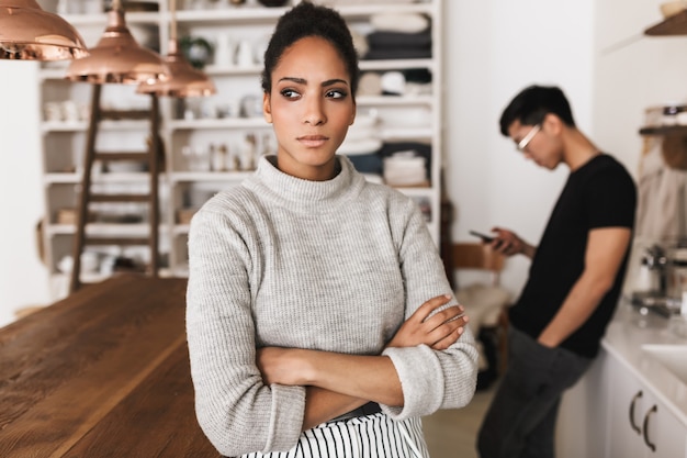 Upset african american woman holding hands together thoughtfully 