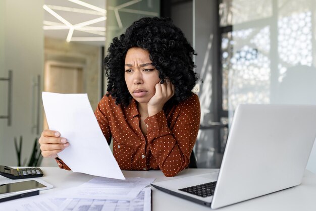 Фото Расстроенная и неудовлетворенная женщина на рабочем месте, босс-бизнесвумен проверяет счета документов и