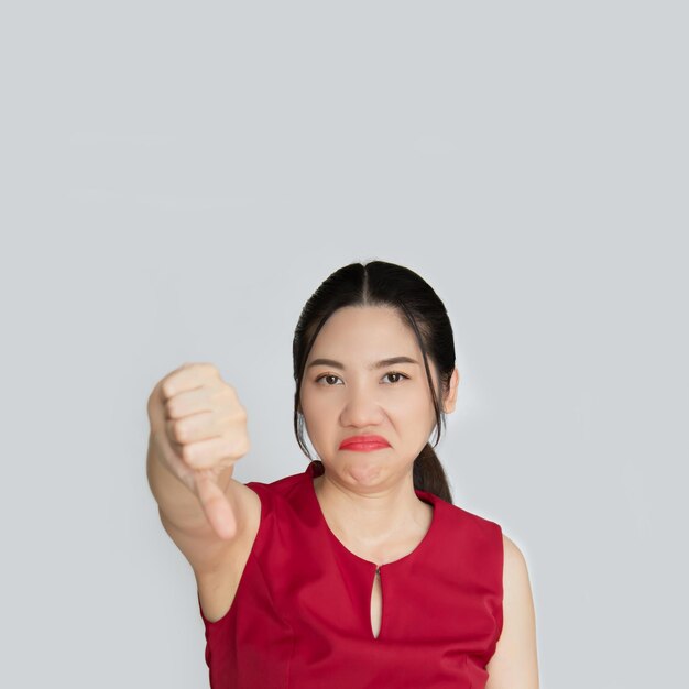 Upset beautiful Asian woman with a frowning sad grimacing disappointed show thumbsdown give negative opinion