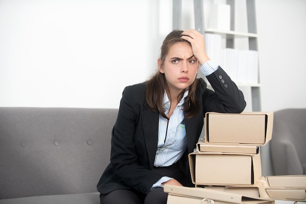 Upset business woman on folders with the documents unhappy secretary girl working overtime at office