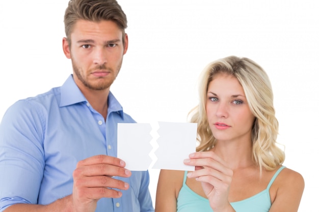 Photo upset couple holding torn piece of paper