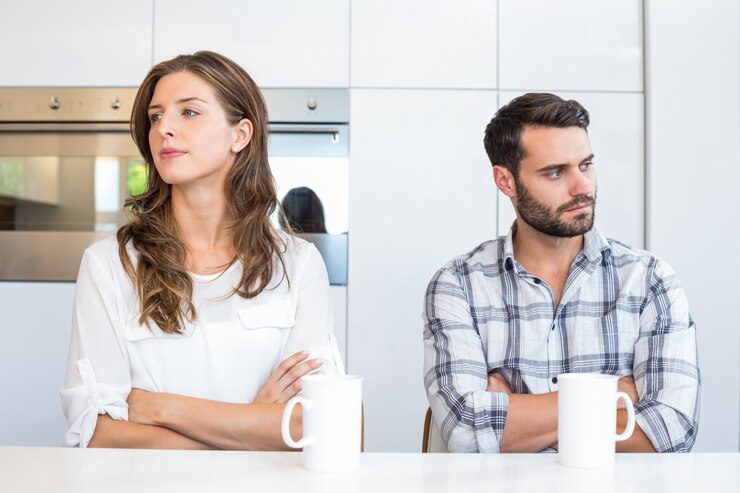 Photo upset couple sitting by table