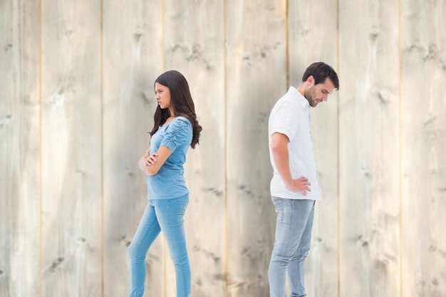 Upset couple not talking to each other after fight against pale wooden planks