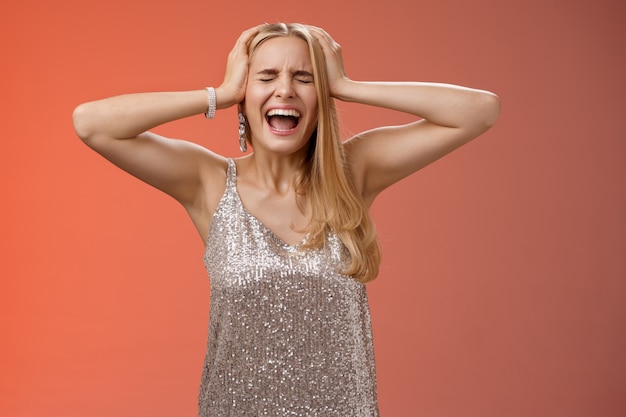 Upset distressed pressured fed up panicking young blond woman in dress scream