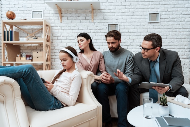 Upset girl in headphones family therapy session