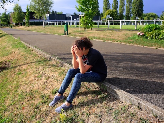 Upset girl sitting in the school yard