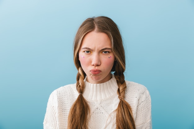 Upset girl wearing sweater standing isolated